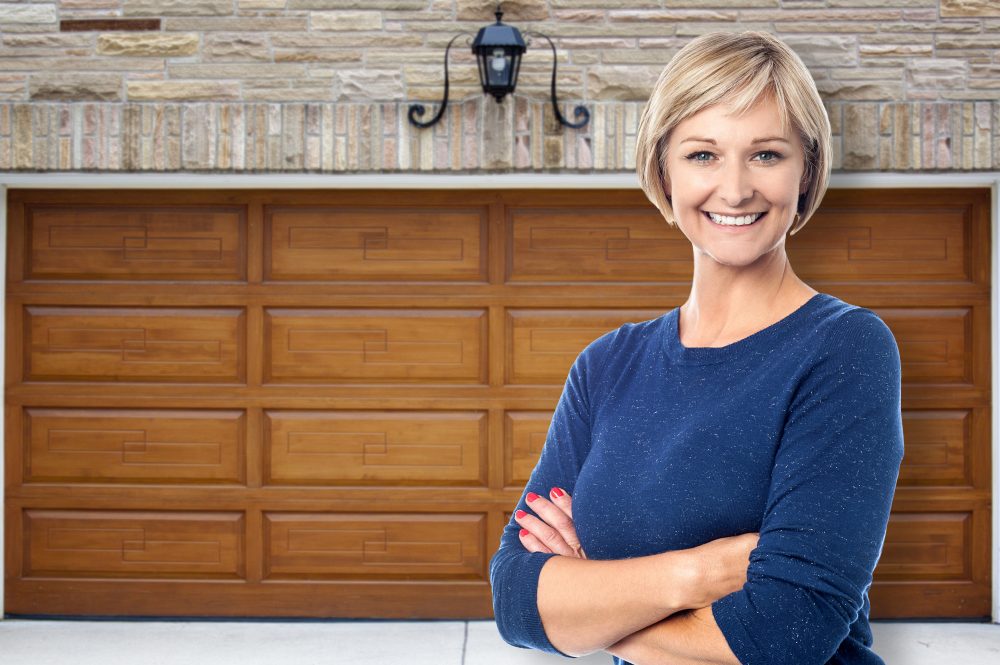 Smiling woman in front of rolling garage doors in Fergus, Ontario